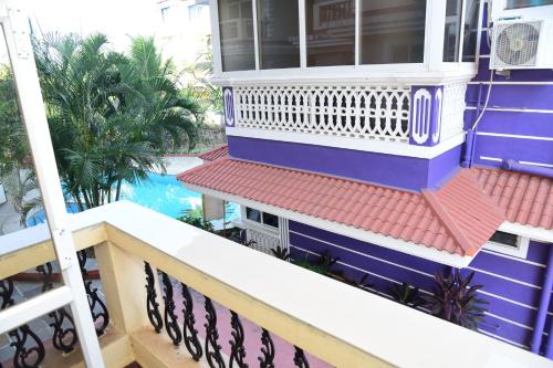 a blue house with a balcony and a swimming pool at Dona Rosa Holiday Apartment in Varca