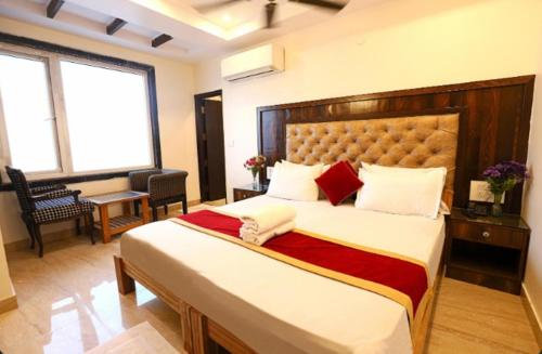 a bedroom with a large bed in a room at Hotel Atlantis Continental in New Delhi