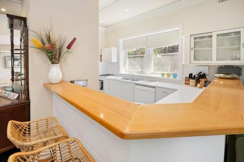 een keuken met een houten aanrecht en een wastafel bij Coral Rose Cottage in Capel Sound