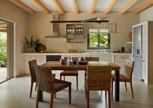 a kitchen with a wooden table and chairs at F ZEEN Kefalonia in Lourdhata