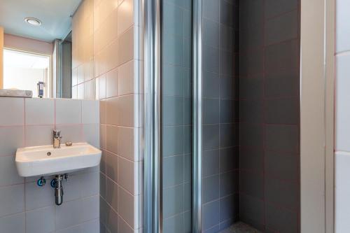a bathroom with a sink and a shower at The Tropicana Hotel in Cape Town