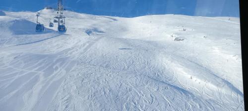 a snow covered ski slope with a ski lift at Lodge Pizzo Alpestre in Abetone