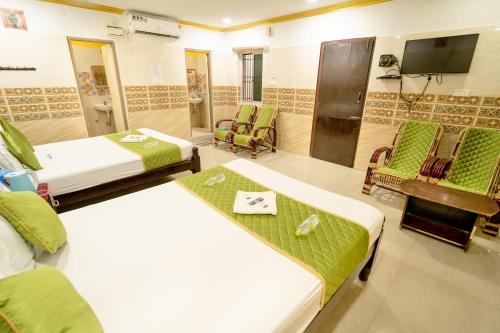 a hotel room with two beds and a tv at Sri Vinayaga Residency in Rāmeswaram