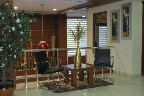 a lobby with two chairs and a table with a vase at Lifos Hotel in Kayseri