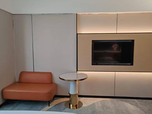 a living room with a chair and a table and a fireplace at WAIFIDEN Hotel -Former Tokai Hotel - Xiaobei Metro Station - During the Canton Fair, there will be shuttle buses for transportation back and forth in Guangzhou