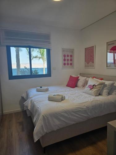 a large bed in a bedroom with a window at לוי-קיישן מגוון דירות גן ופנטהאוזים וסוויטות נוף ברחוב הצנחנים in Tiberias