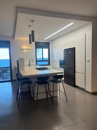 a kitchen with a island with bar stools in it at לוי-קיישן מגוון דירות גן ופנטהאוזים וסוויטות נוף ברחוב הצנחנים in Tiberias