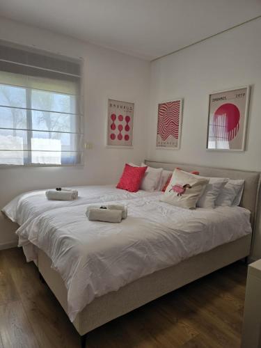 a large bed in a bedroom with two pillows on it at לוי-קיישן מגוון דירות גן ופנטהאוזים וסוויטות נוף ברחוב הצנחנים in Tiberias