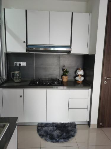 a kitchen with white cabinets and a black counter top at SKS Larkin Stadium Larkin Terminal Bus Town Area JB City in Johor Bahru