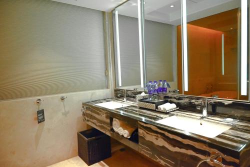 a bathroom with two sinks and a large mirror at Pullman Wenzhou in Wenzhou