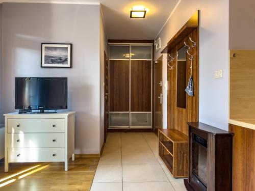 a living room with a television and a dresser at Villa 4 Pory Roku in Jastrzębia Góra