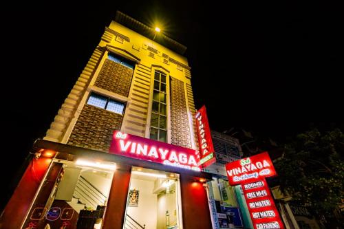 a building with neon signs in front of a restaurant at Sri Vinayaga Residency in Rāmeswaram