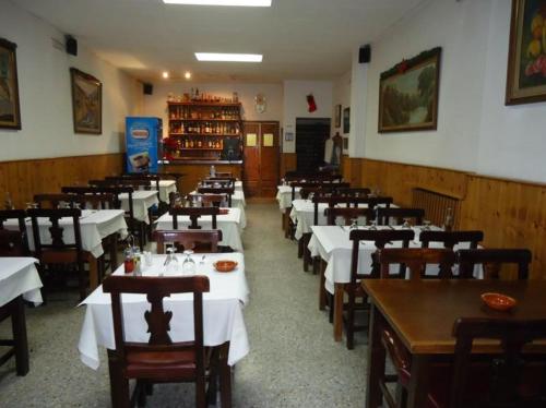 アンドラ・ラ・ベリャにあるResidència Restaurant Indaloのダイニングルーム(テーブル、椅子、白いテーブル付)