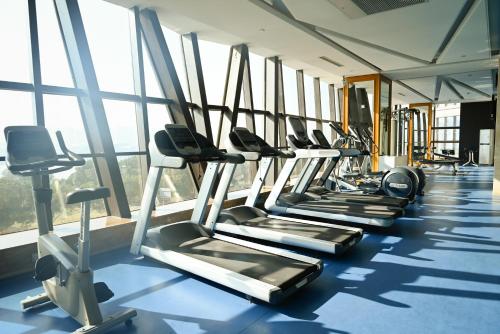 a row of treadmills in a gym with windows at Pullman Wenzhou in Wenzhou