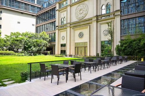 a group of tables and chairs in front of a building at Pullman Wenzhou in Wenzhou