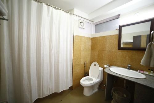 a bathroom with a toilet and a sink and a mirror at Hotel Sikkim Tourist Centre in Pelling