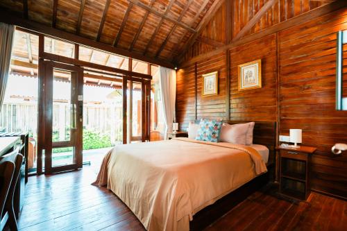 Postel nebo postele na pokoji v ubytování Ngesil Private Joglo & Pool