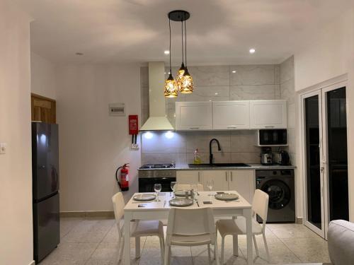a kitchen with a white table and chairs in a room at Coco Vanille Chalets in Takamaka