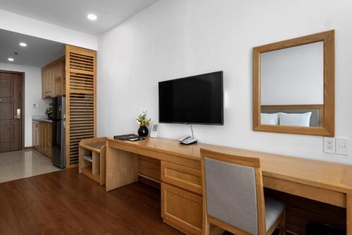 a room with a desk with a television on the wall at Sunflower International Village in Hai Phong