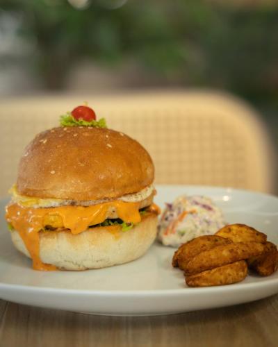 a sandwich on a plate with a side of potatoes at Paprika Stays Panjim Donapaula in Panaji