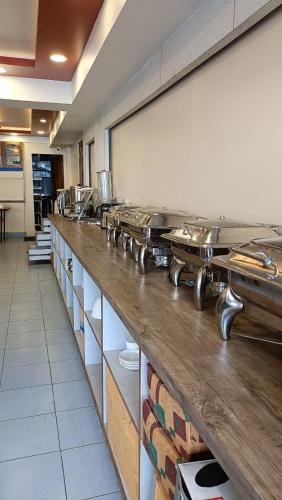 a kitchen with a long counter with many pans at HOTEL RUDRA BHAWAN, 6 Minutes to Mall Rd in Darjeeling