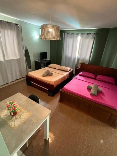 a bedroom with two beds and a table with a pink sheet at Lariad BNB in Rivière Noire