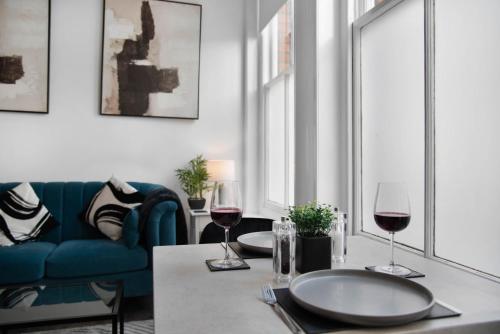 a living room with a table with two glasses of wine at WhiskAwayStays Foregate Studio No 2 in Worcester