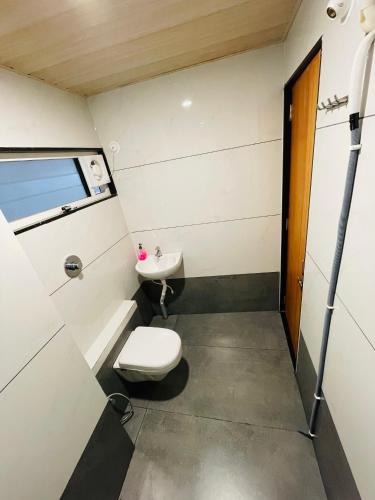 a bathroom with a toilet and a sink at Hotel Coastal Empire in Belgaum