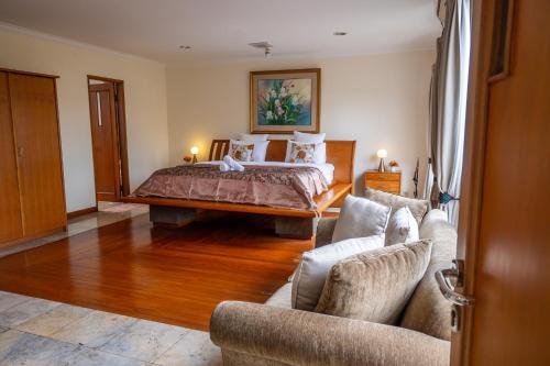 a bedroom with a bed and two couches at Pasteur Beautiful Luxury Home in Bandung