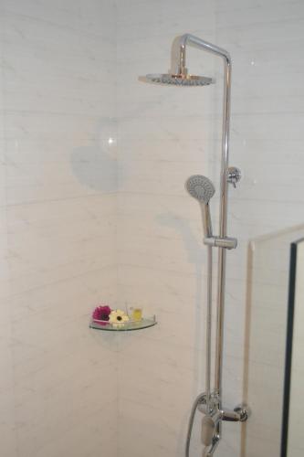 una doccia con un piatto di fiori su uno scaffale di Ashley Boutique Hotel a Kota Damansara