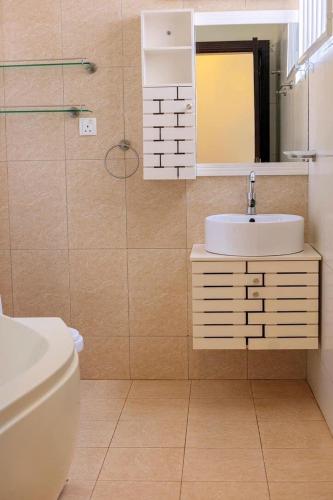 a bathroom with a sink and a toilet and a mirror at 3 Bed Luxury Condo in Lubowa in Kampala
