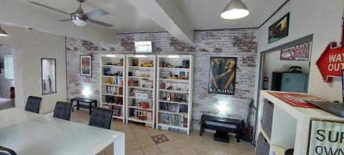 un comedor con una mesa y un estante de libros en La Longère Des Nuits De Varenne, en Muchedent