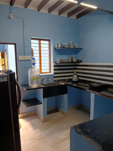 a kitchen with a sink and a blue wall at KHS -Temple View in Ambāsamudram