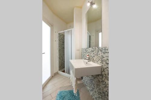 a bathroom with a white sink and a mirror at Holiday home Isola Rossa in Isola Rossa