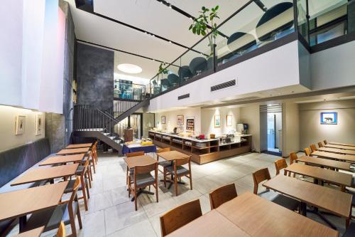a restaurant with wooden tables and wooden chairs at Best Western Plus Hotel Fino Osaka Kitahama in Osaka