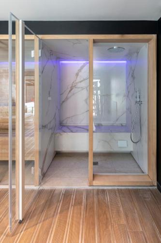 a room with a glass wall with a shower at Le Cornouaille Hotel & Spa in Bénodet