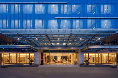 a large blue building with a lot of windows at Hotel Neo Plus Airport Jakarta in Tangerang