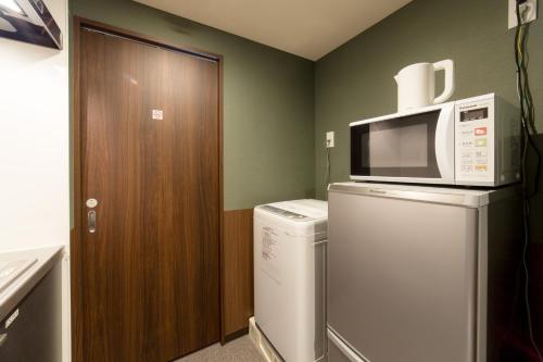 a microwave on top of a washer and dryer in a room at Kyoto Sanjo Ohashi in Kyoto