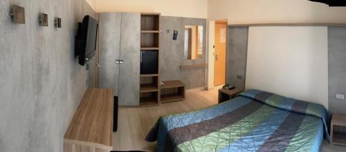 a bedroom with a bed and a tv on a wall at Hotel Ricchi in Rimini