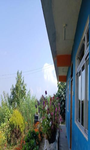 a blue house with flowers on the side of it at Yangzon Homestay By StayApart in Simāna Basti