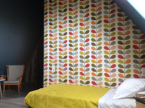 a bedroom with a bed with a colorful wall at Le Saint Aubin- Maison d hôtes dans ce monastère du 16 siècle in Amfreville-la-Campagne