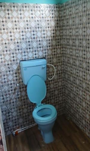 a bathroom with a blue toilet in a room at Yangzon Homestay By StayApart in Simāna Basti