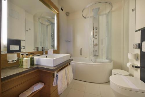 a bathroom with a sink and a shower and a toilet at MOTA hotel in Livigno