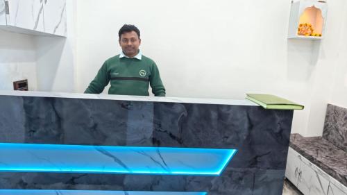 a man standing behind a counter with at Neelkanth pg house in Varanasi