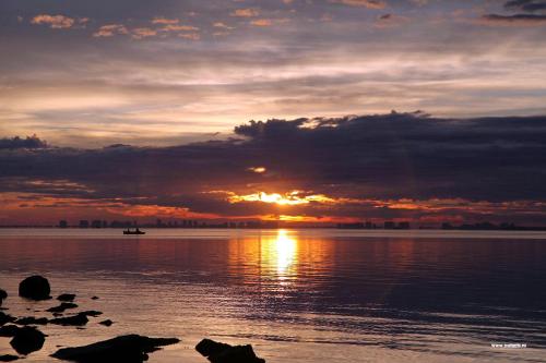 a sunset over a body of water with the sun setting at Hotel Cristina in Los Alcázares