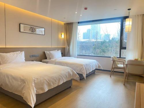a hotel room with two beds and a window at 隐栖堂酒店 成都太古里合江亭店 in Chengdu