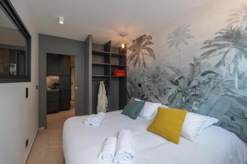 une chambre avec un lit blanc avec des serviettes dessus dans l'établissement City Astoria An urban appartement, à Aix-les-Bains