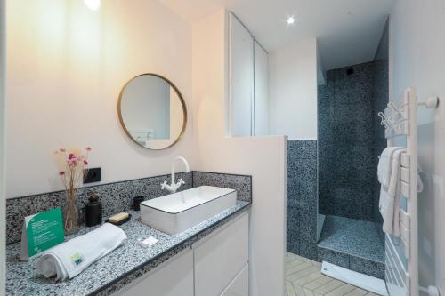 une salle de bain avec un lavabo et une douche dans l'établissement City Astoria An urban appartement, à Aix-les-Bains
