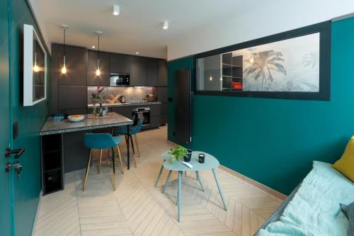 d'une cuisine et d'un salon avec un mur bleu. dans l'établissement City Astoria An urban appartement, à Aix-les-Bains