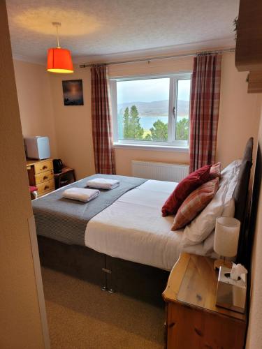 a bedroom with a large bed and a window at Corran House in Kingsburgh